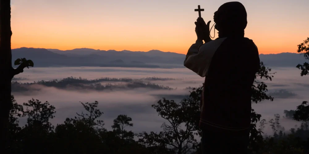 silhouette-human-hand-holding-cross-background-is-sunrise